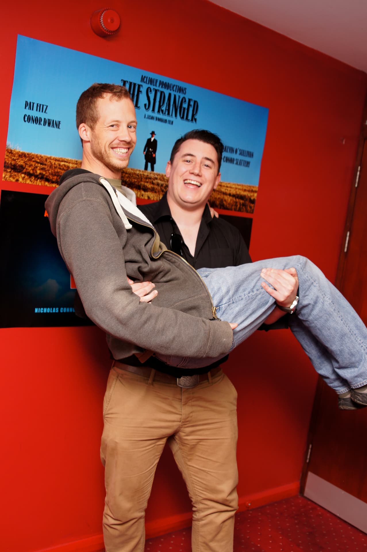 Guests joking in front of The Stranger poster at the premiere